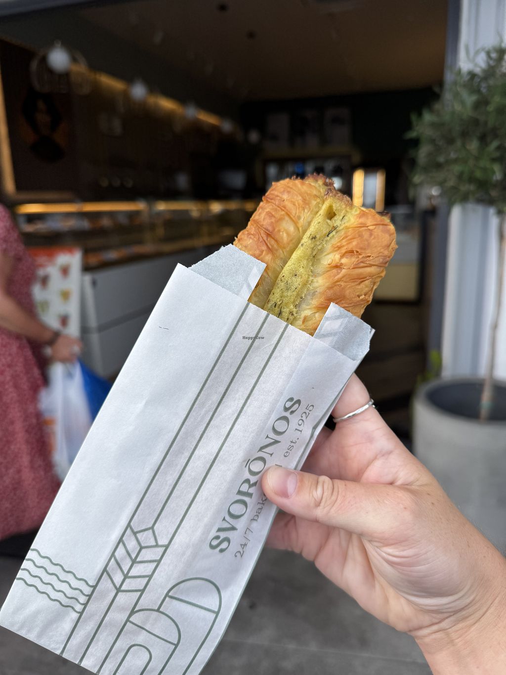 Hand-held savory pastry outside Svoronos Bakery